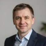 Портрет уверенного российского бизнесмена с дружелюбным взглядом на нейтральном размытом фоне в студии