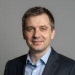 Портрет уверенного российского бизнесмена с дружелюбным взглядом на размытом нейтральном фоне в студии